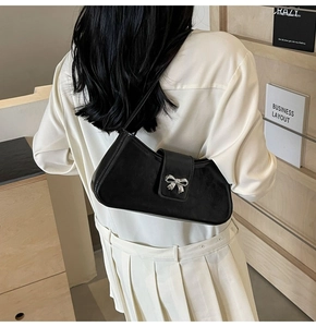 Detail der minimalistischen schwarzen Baguette-Tasche mit silberner Schleifenschnalle