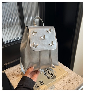 Detailed close-up of a silver fashion mini backpack with five 3D metal butterfly ornaments