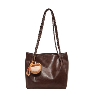 Minimalist coffee brown oil wax leather tote bag with woven straps and plush pendant charm