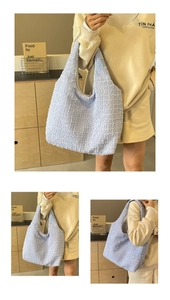 Macro shot of light blue pleated bucket bag with rich 3D woven texture and wide strap