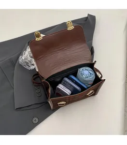 Detail view of large capacity interior for umbrella and phones in British plaid messenger bag