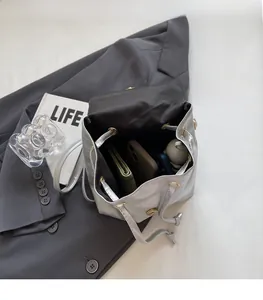Spacious interior of silver metallic drawstring bucket bag with essentials inside