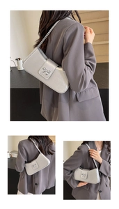 Silbergraue Baguette-Tasche mit metallischer Schleifenschnalle und glänzendem Finish