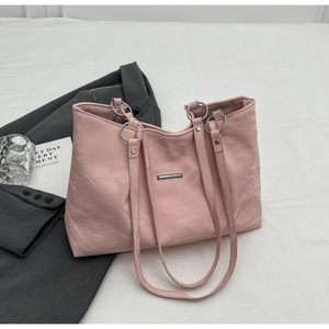 Detail of pink PU leather tote bag with wrinkled texture and silver metal hardware