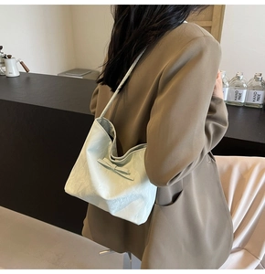 Détail du sac seau vert menthe avec nœud décoratif et texture en cuir brillant
