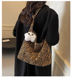 Detail of large leopard print hobo bag with white plush star charm and shoulder strap