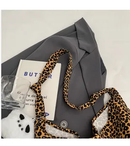 Detail of trendy leopard print shoulder strap and large tote bag with stylish accessories