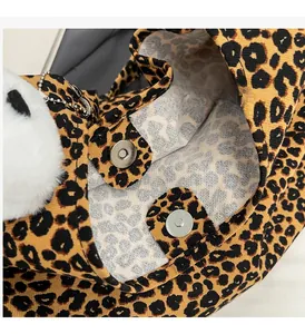 Detail view of leopard print canvas tote bag with magnetic snaps and plush charm