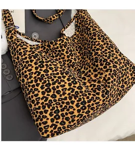Macro detail of leopard print tote bag with soft fabric texture and a cute white pom pom