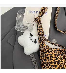 Close-up of leopard print shoulder bag with a white plush star pendant decoration