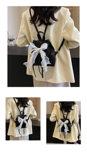 Close-up of stylish black bucket backpack featuring a decorative white lace ribbon bow