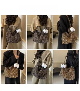 Detail view of a large leopard print canvas tote bag with a white star plush charm