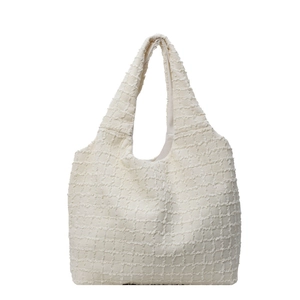 Minimalist beige oversized tote bag with textured waffle fabric and integrated shoulder strap