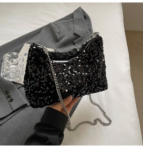 Sac croissant à paillettes noires avec chaîne argentée sur blazer gris et linge blanc