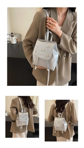 Detail of silver metallic backpack with butterfly charms and drawstring closure