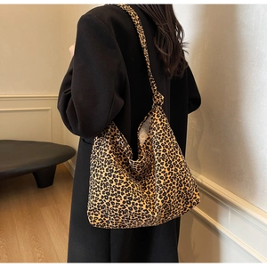 Detailed view of leopard print tote bag with stylish knotted strap on black coat