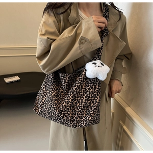 Detail of leopard print tote bag with plush star charm and spacious canvas design