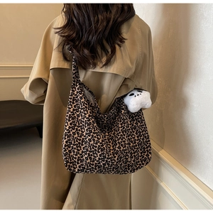 Detailed view of large leopard print tote bag with soft plush doll charm and camel coat