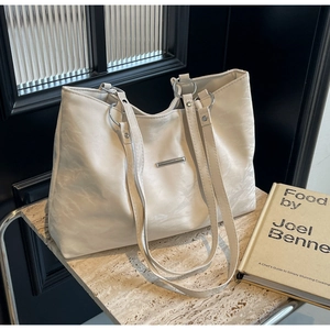 Minimalist cream white leather tote bag with pleated texture on stone background