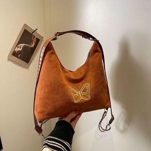 Brown faux suede shoulder bag featuring yellow butterfly embroidery and metal chains
