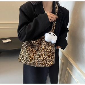 Detail of large leopard print tote bag with a white star plush charm and single strap