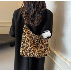 Close-up of leopard print tote bag with a plush panda charm on a model's shoulder