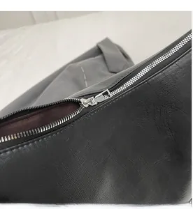 Close-up of high-quality smooth silver metal zipper on a black leather tote bag detail