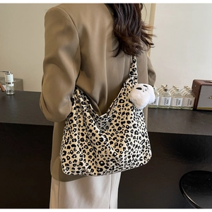 Detail shot of large leopard print tote bag with cute plush charm and canvas texture