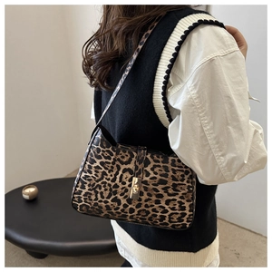 Sac sous le bras à imprimé léopard avec boucle dorée porté par un mannequin chic