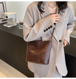 Detail of vintage dark brown faux leather bucket bag with Fashion and Sunday embossed text