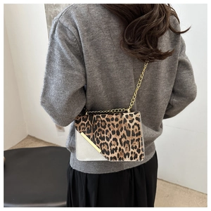 Detail of leopard print crossbody bag featuring gold metal bar and elegant chain strap