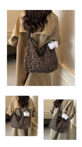 Detail of large leopard print tote bag with plush panda charm on casual khaki trench coat