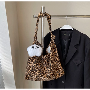 Detail of leopard print canvas tote bag with adjustable knotted strap and panda charm