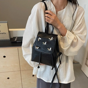 Chic black mini PU leather backpack with silver butterfly accents and drawstring closure
