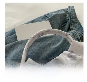 Detailed view of woven fabric texture and grey floral patterns on the cloud bag strap