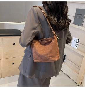 Close-up of brown suede hobo bag with Fashion and Sunday text being worn by a model