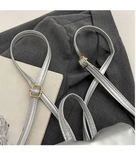 Close-up of adjustable strap with gold metal buckle on silver leather backpack bag