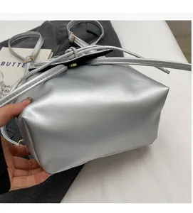 Detail of silver faux leather backpack with metallic luster and drawstring closure