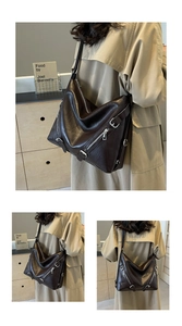 Detail view of large dark brown leather tote bag with silver zippers and buckle straps