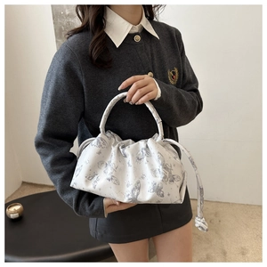 Detail of gathered top handle and delicate light grey butterfly pattern on white bag