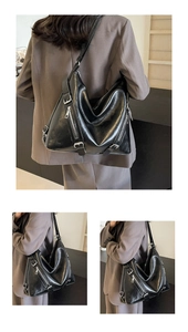 Detail view of large black tote bag with silver zippers and textured leather finish