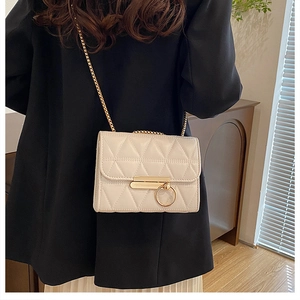 Chic cream quilted crossbody bag featuring elegant gold chain strap and ring lock detail
