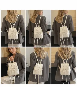 Detail of mini PU leather backpack featuring ribbon bow accents and drawstring closure