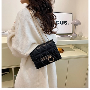 Chic black quilted crossbody bag with gold chain strap and ring lock on model