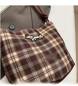 Detail of checkered bucket bag featuring a cute dachshund embroidery and knotted strap