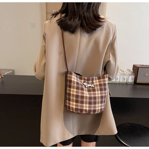 Model view of a brown plaid shoulder bag featuring a cute dachshund puppy embroidery