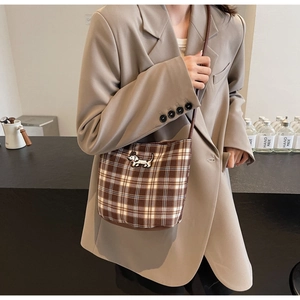 Close-up of retro plaid bucket bag with dachshund embroidery and leather strap detail