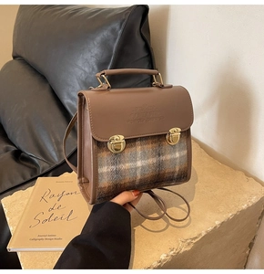 Close-up of vintage plaid handbag with Fantastic embossed flap and gold twist locks