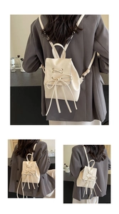Detail of cream PU leather mini backpack with decorative criss-cross lacing and bow tie