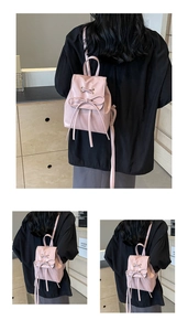 Detail of pink mini backpack with a satin bow and adjustable shoulder straps